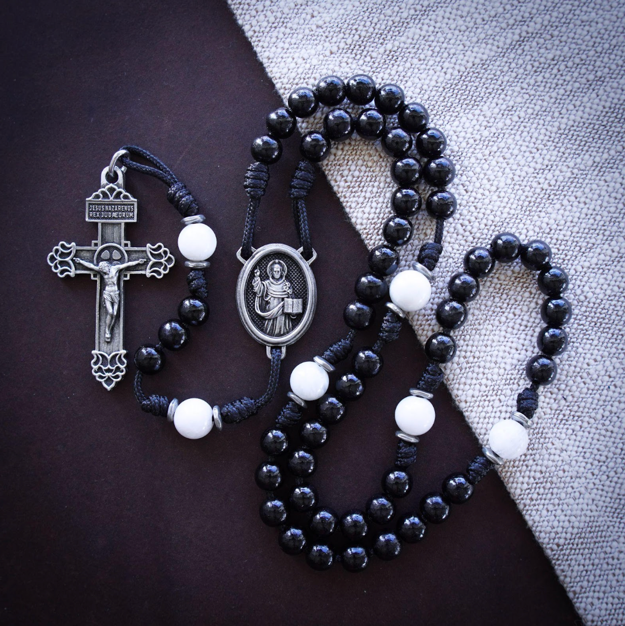 Man holding Rosary in quiet prayer — tired but faithful